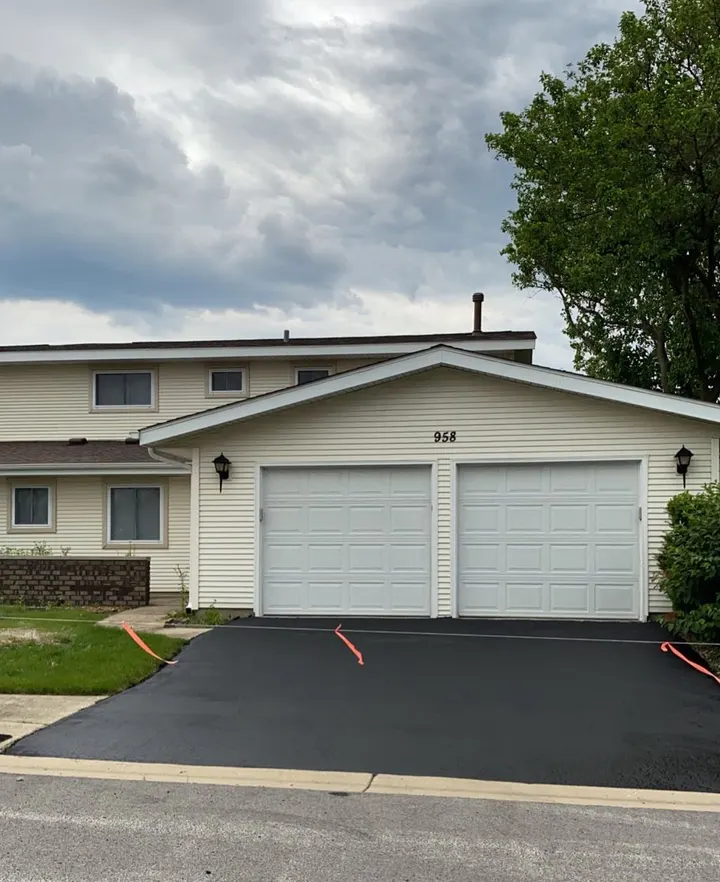 Sealcoated driveway outside a split-level home with two garage doors