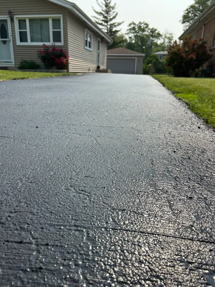 Close view of textured driveway asphalt leading toward a garage