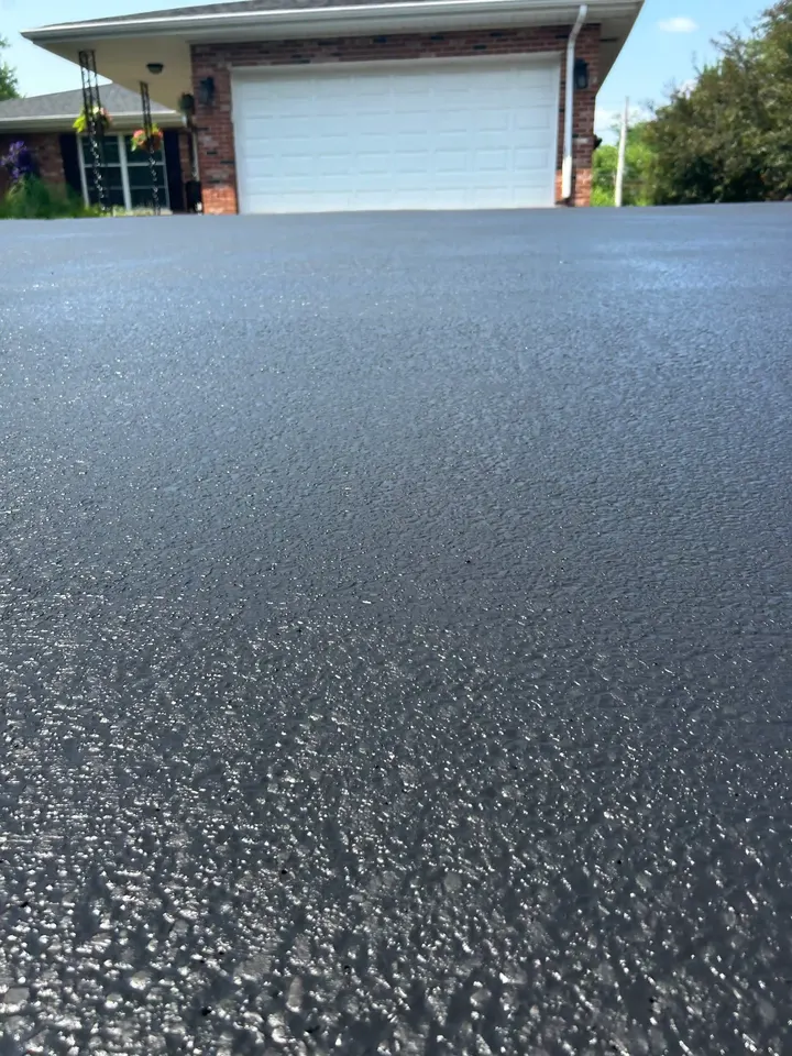 Close-up asphalt texture with a white garage in the background
