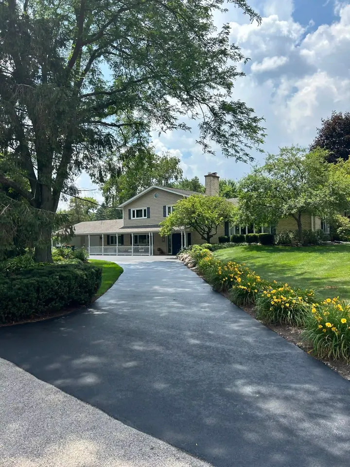 Curving driveway leading through landscaped grounds toward a house