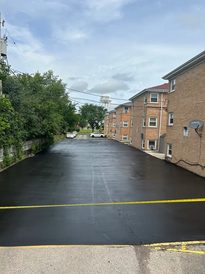Paved parking area beside a brick building, blocked off with yellow tape