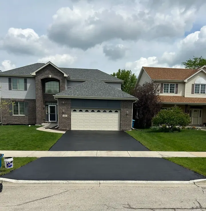 Sealcoated driveway outside a brick and stone home