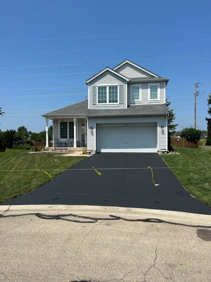 Finished driveway outside a blue house with yellow blockoff tape